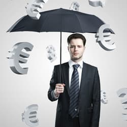 Man with an umbrella, as foreign currency signs fall around him