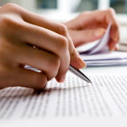 Woman holding pen over business documents