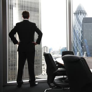 Man standing in front of huge glass office windows