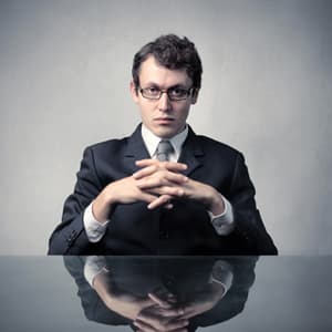 Stern looking employee sitting behind a desk