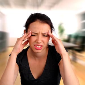 Woman holding her fingers at temples, looking stressed