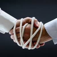 Men, shaking hands, with ropes bound around hands