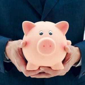 businessman holding pink piggy bank