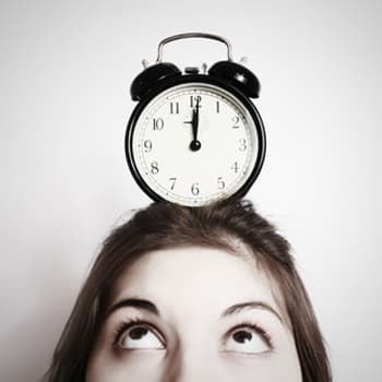 Woman with alarm clock on head