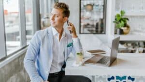 man sitting beside white wooden table