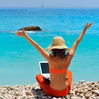 Woman on the beach with her laptop