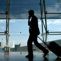 Man on a mobile phone, walking through an airport
