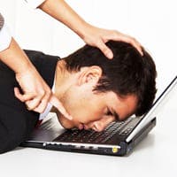Man with head shoved on computer