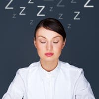 Businesswoman falling asleep at her desk