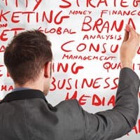 Man writing business terms on a whiteboard