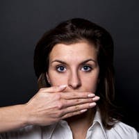 Woman with a hand covering her mouth