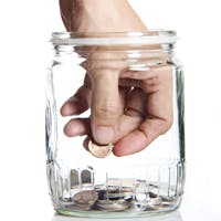 Hand reaching into an almost empty money jar