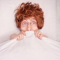 woman having a nightmare, covers over her mouth