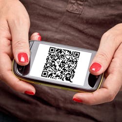 Woman holding a mobile phone with a QR code on its screen