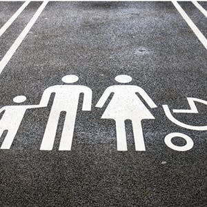Parking spot, with silhouette of parents, child and pram