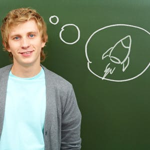 Young man standing in front of blackboard, with an idea bubble