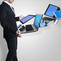 Man with various business technologies in front of him