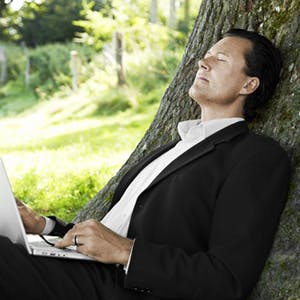 Business man dreaming under trees