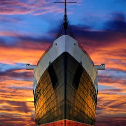 Giant ship in front of colourful sunset