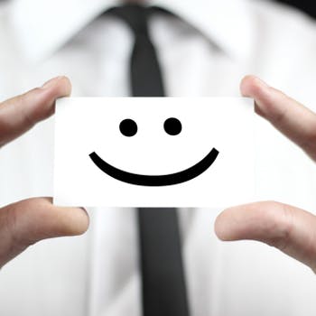 Smiley face on a card, being held up by businessman