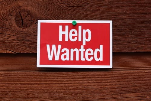 help wanted sign on wooden background